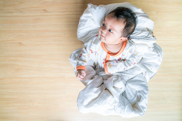Adorable infant baby lying in wood basket with blanket - Foto, afbeelding