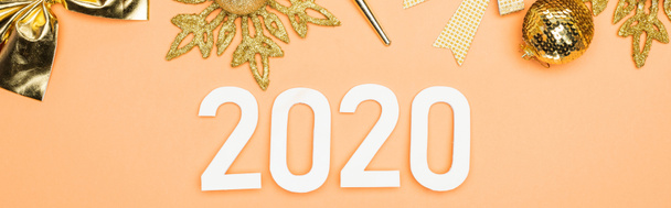 ylhäältä näkymä valkoinen 2020 numerot lähellä kultainen joulu koristelu oranssi tausta, panoraama laukaus
 - Valokuva, kuva