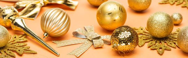festive shiny golden christmas decoration on orange background, panoramic shot - Фото, изображение