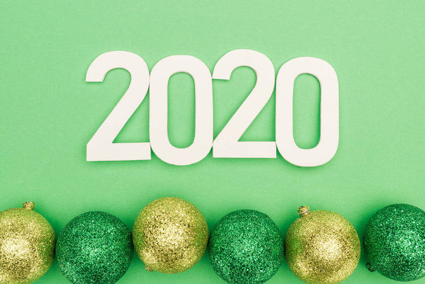 vue du haut des chiffres blancs 2020 près des boules de Noël sur fond vert
 - Photo, image