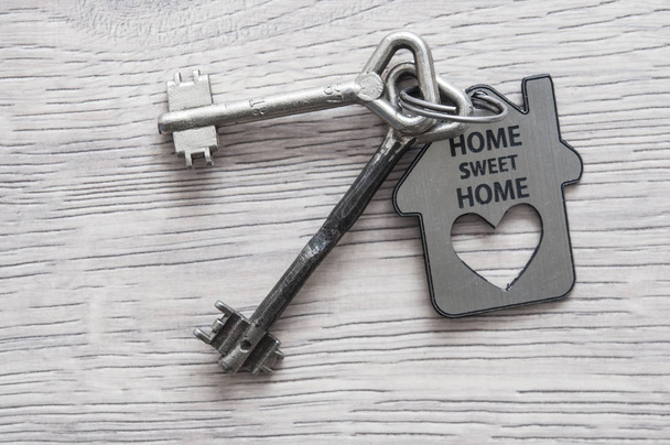 chaves de metal velhas com símbolo de uma casa de família no backg de madeira
 - Foto, Imagem
