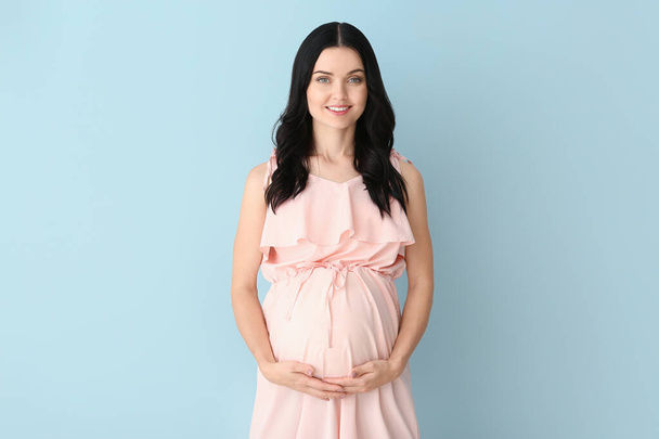 Красивая беременная женщина на цветном фоне
 - Фото, изображение