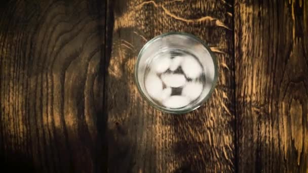 Les glaçons se déplacent dans un verre embrumé sur un fond de table
 - Séquence, vidéo