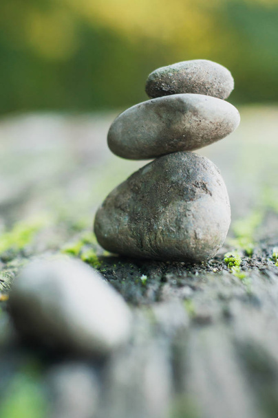 Closeup of stone balance of pebbles on wooden table in outdoor  - Foto, Bild