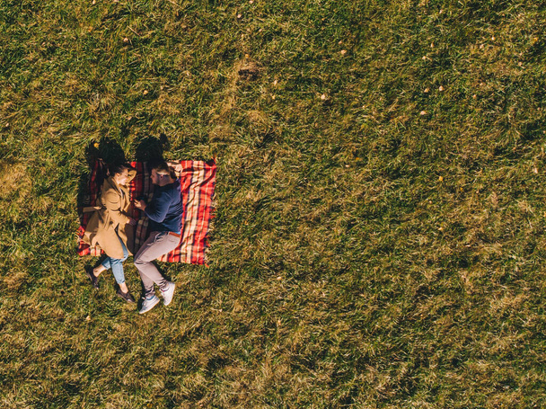 couple at blanket on grass overhead view - Фото, изображение