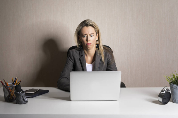 Frustrierte Geschäftsfrau schaut auf Laptop - Foto, Bild