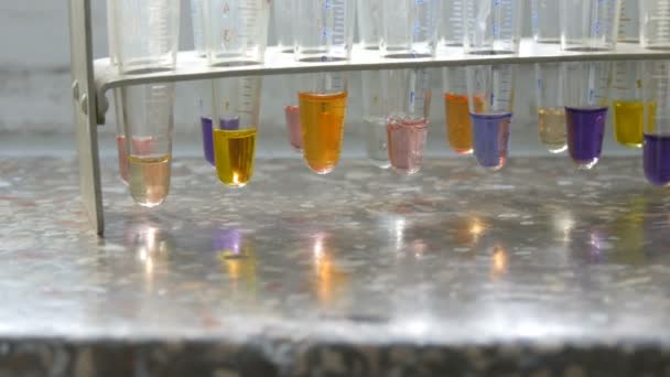 Πολλοί διαφορετικοί δοκιμαστικοί σωλήνες με έγχρωμο υγρό νερό στο εργαστήριο με αντιδραστήρια σε παλιό παράθυρο με μαρμάρινο περβάζι παραθύρου. - Πλάνα, βίντεο
