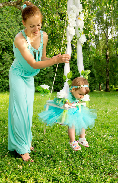 Mother and baby on a swing on nature - Фото, зображення