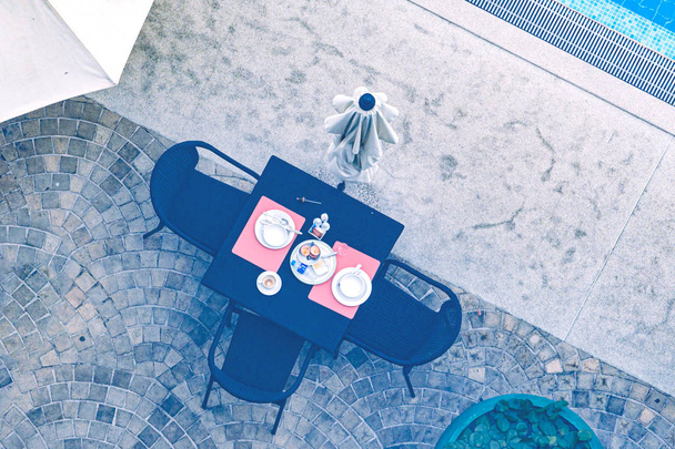 Mesa junto a la piscina, con utensilios usados, vista superior
. - Foto, Imagen