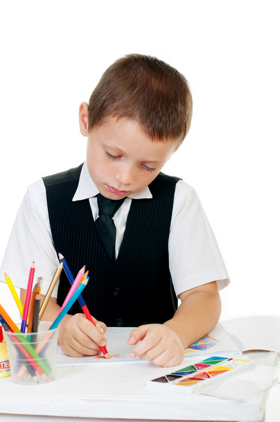 The boy draws pencils in an album on a white background - Фото, зображення