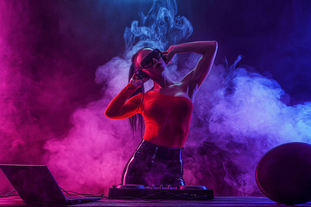 Jeune femme sexy dj jouer de la musique. Casques et mixeur DJ sur la table
. - Photo, image
