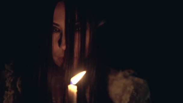 Psychotic woman burning candle and looking around in darkness, mental disorder - 映像、動画