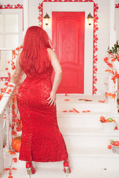 Beyaz sarayının verandasında kırmızı maksi elbise giyen genç ve şık tombul bir kadın. Sonbahar modası, zarif görünüş. Artı boyut modeli. - Fotoğraf, Görsel