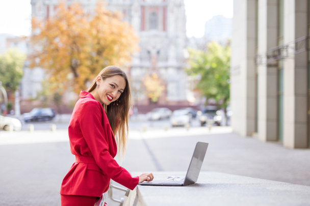 Attractive young woman using laptop outdoors  - Φωτογραφία, εικόνα