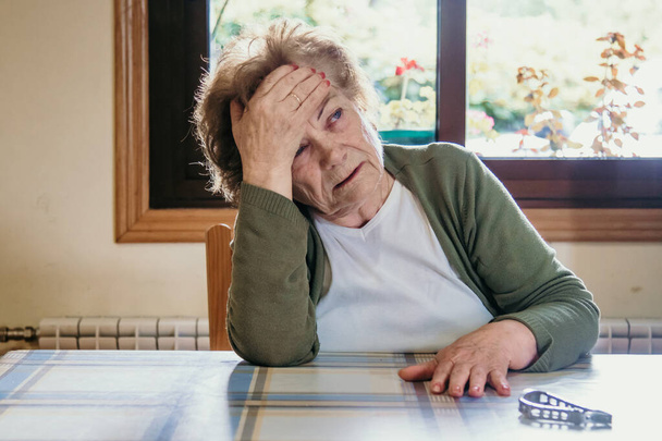 arckép egy fejfájásos idős nőről - Fotó, kép