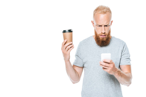 worried bearded man with coffee to go talking on smartphone, isolated on white - Photo, Image