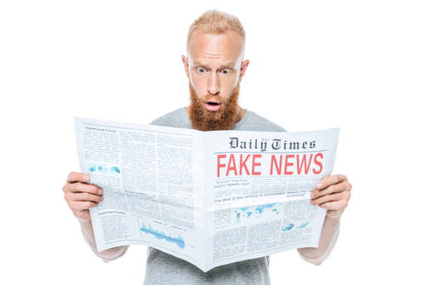 Schockierter bärtiger Mann liest Zeitung mit Fake News, isoliert auf weiß - Foto, Bild