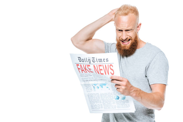 confused bearded man reading newspaper with fake news, isolated on white - Photo, Image