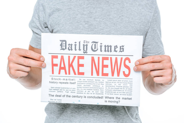 partial view of man showing newspaper with fake news, isolated on white - Φωτογραφία, εικόνα