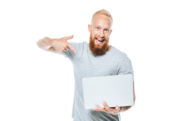 excited bearded man pointing at laptop, isolated on white - 写真・画像