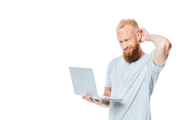 confused bearded man using laptop, isolated on white - Foto, Bild