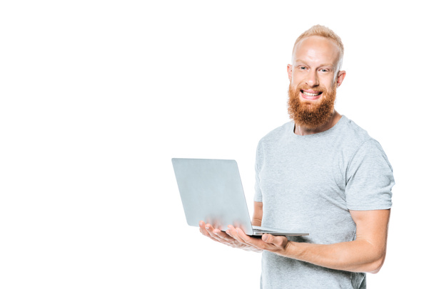 homme barbu joyeux tenant ordinateur portable, isolé sur blanc
 - Photo, image