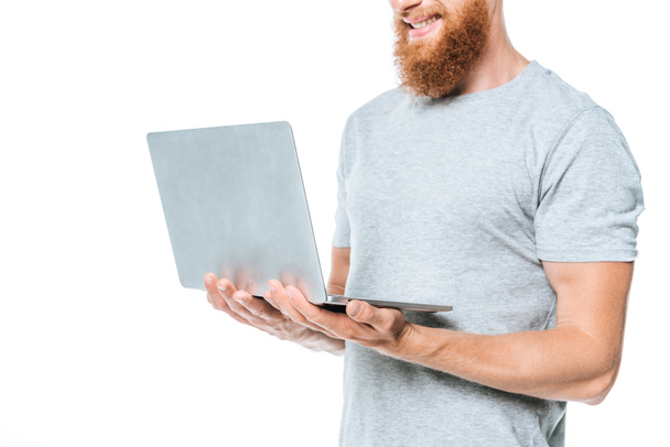 cropped view of smiling bearded man using laptop, isolated on white - Photo, Image