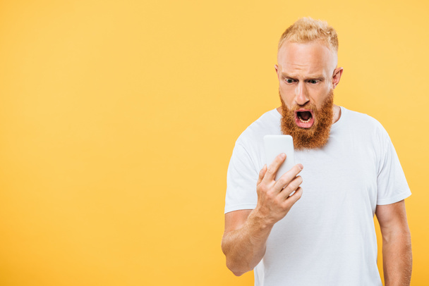 shocked man screaming on smartphone, isolated on yellow - Fotoğraf, Görsel