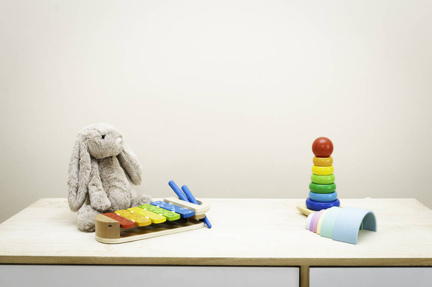 Hintergrund von buntem Kinderspielzeug gegen die Wandspielzeuge auf Holztisch mit Kopierraum für Text - Foto, Bild