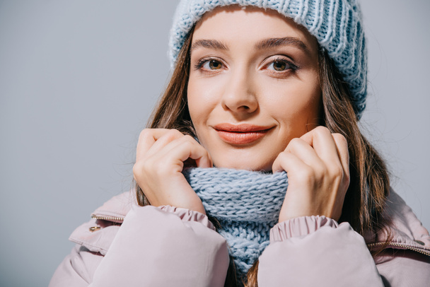 beautiful smiling girl posing in coat, knitted hat and scarf, isolated on grey - Fotoğraf, Görsel