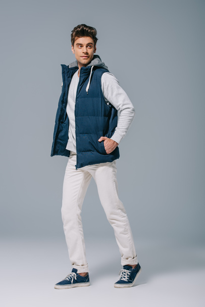 fashionable male model posing in autumn waistcoat on grey - Foto, imagen