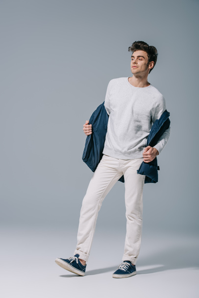 handsome fashionable man posing in trendy waistcoat on grey - Foto, immagini