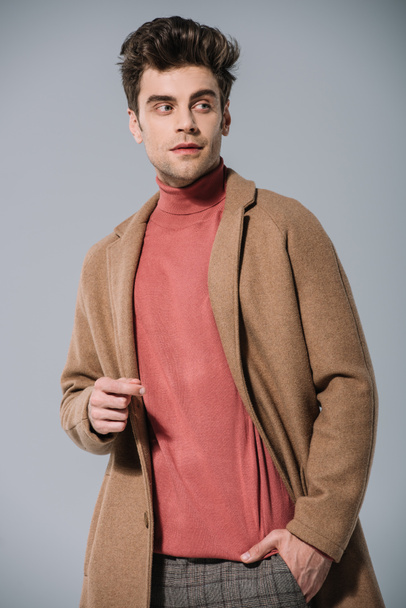 stylish man posing in beige coat, isolated on grey - 写真・画像
