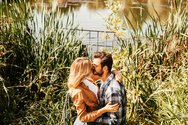felice giovane coppia che abbraccia e abbraccia in boscaglia di carice vicino al lago
 - Foto, immagini