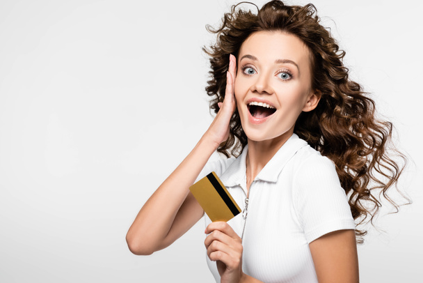 beautiful surprised girl holding credit card, isolated on white - 写真・画像