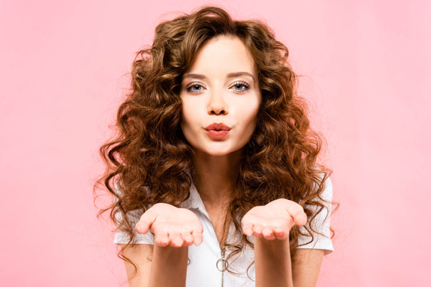 beautiful happy curly girl blowing air kiss, isolated on pink - Zdjęcie, obraz