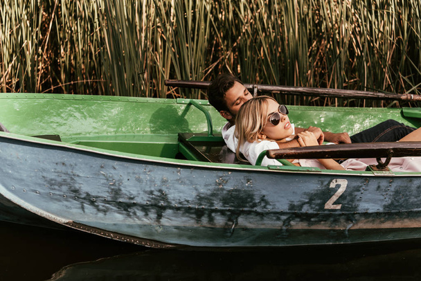 jeune couple se relaxant en bateau sur la rivière près d'un bosquet de carex
 - Photo, image