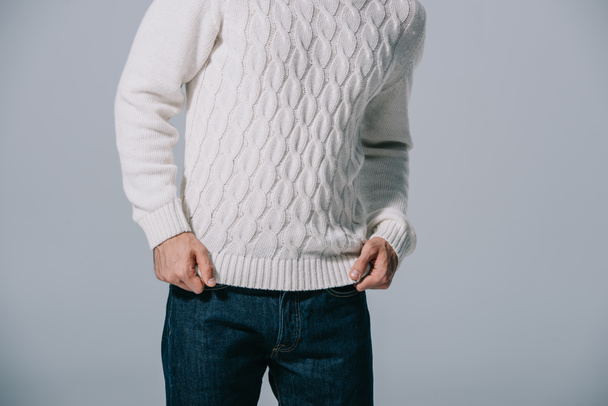 cropped view of man posing in white knitted sweater, isolated on grey - Fotó, kép