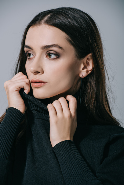 attractive stylish girl posing in black sweater, isolated on grey - Photo, Image