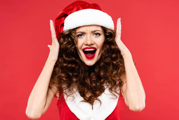 beautiful surprised girl posing in santa costume, isolated on red - Fotoğraf, Görsel
