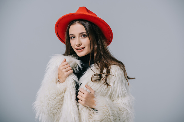 sorridente ragazza elegante in posa cappotto di pelliccia alla moda e cappello rosso, isolato su grigio
 - Foto, immagini