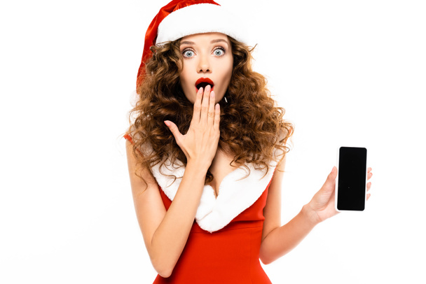 surprised girl in santa costume showing smartphone with blank screen, isolated on white - Photo, Image