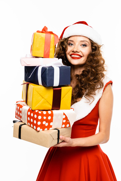 happy girl in santa costume holding stack of gifts, isolated on white - Foto, imagen