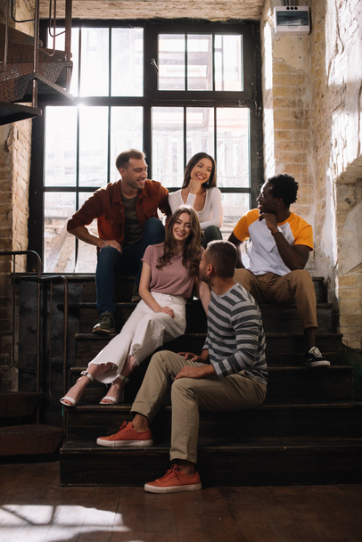 positif, jeunes entrepreneurs multiculturels parlant tout en étant assis sur les escaliers
 - Photo, image