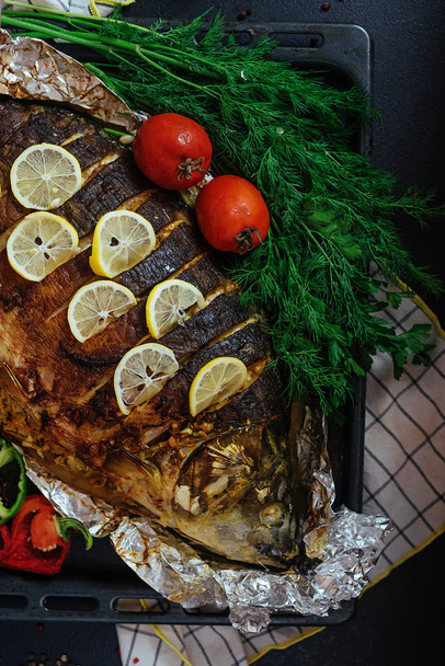 Pečené ryby řeka kapra s aromatickými bylinkami, kořením, solí, zeleninou, citronem, česnekem, top view, zdravé jídlo, strava nebo vaření koncepce. - Fotografie, Obrázek