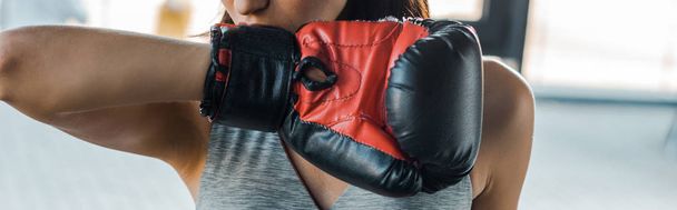 panoramic shot of sportswoman in boxing glove in sports center  - Photo, Image