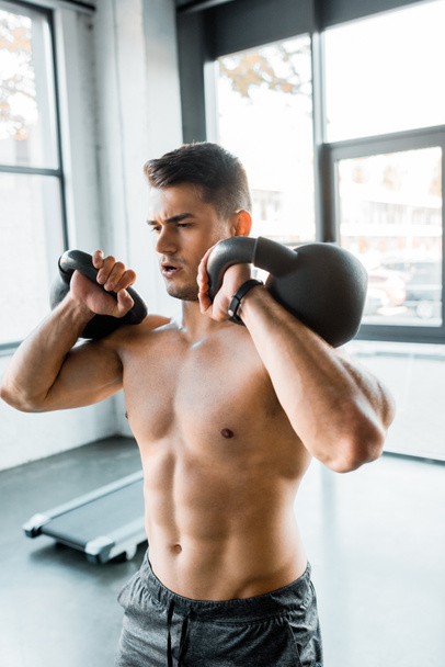handsome sportsman working out with weights in sports center  - Fotografie, Obrázek