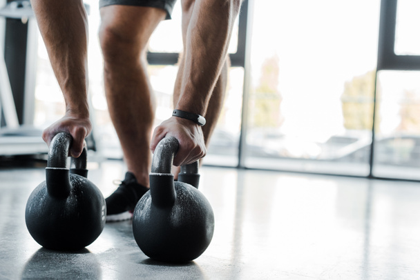 Ausgeschnittene Ansicht eines Sportlers, der im Sportzentrum mit Gewichten trainiert  - Foto, Bild