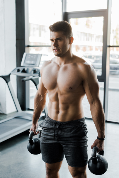 handsome sportsman working out with weights in sports center  - Fotoğraf, Görsel