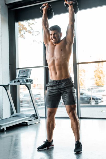 handsome sportsman working out with weights in sports center  - Fotoğraf, Görsel